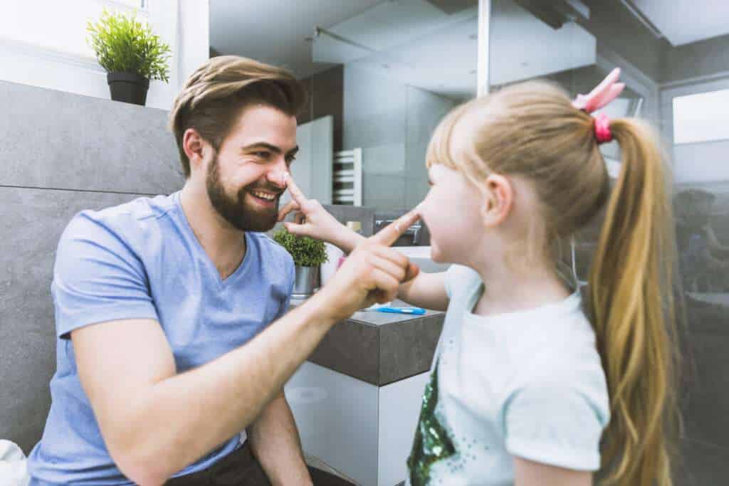 father-daughter-smearing-cream-noses